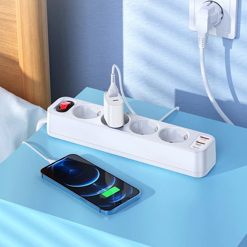 Белая колодка на тумбочке с подключённым адаптером USB-C Колодка с подключённым адаптером USB-C и смартфоном на зарядке